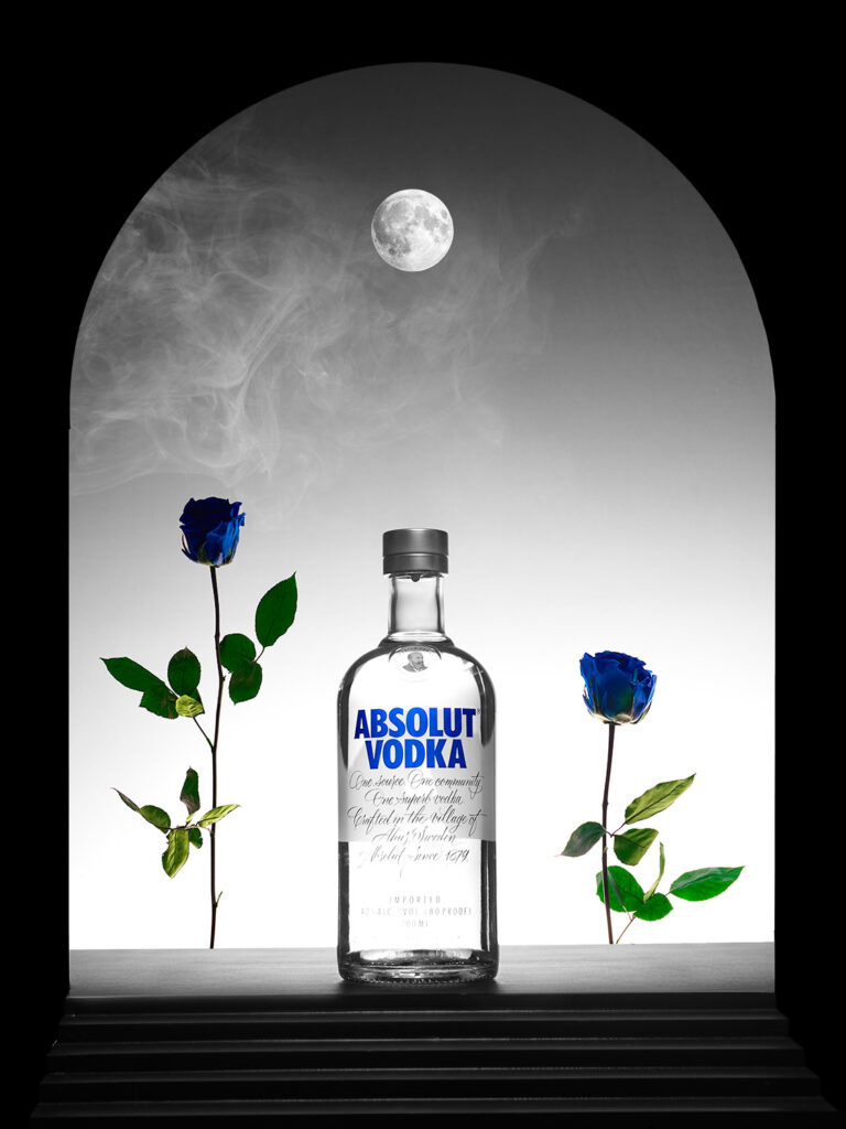 Botella de Absolut vodka con flores azules, escalones y luna