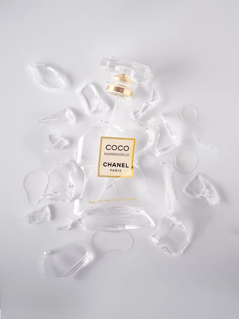 Fotografía de perfume Coco Chanel Mademoiselle roto sobre fondo balnco